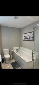 une salle de bain avec baignoire et toilettes dans l'établissement Luxurious Beach Front Apartment in Portrush, à Portrush
