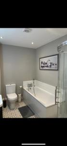 a bathroom with a bath tub and a toilet at Luxurious Beach Front Apartment in Portrush in Portrush