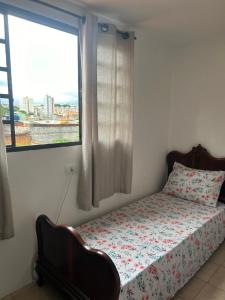 a bedroom with a bed and a large window at Hospedagem Casa da Rê in Salto