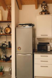 a kitchen with a refrigerator and a microwave at A Casa da Mariana in Casa Nova