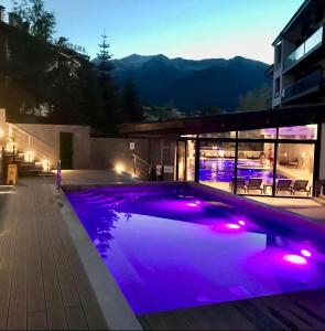 a swimming pool lit up at night with purple lights at 6 Luxury SPA Apartments TOP resort Bansko - incl wellness in Bansko