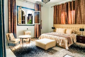 a bedroom with a bed and a chair and a window at Yaf Palace in Marrakesh