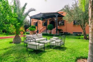 a house with chairs and a couch in the yard at Yaf Palace in Marrakesh