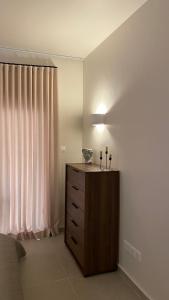 T&L Apartments Agiaos Tychonas في ليماسول: غرفة نوم مع خزانة مع شمعتين عليها
