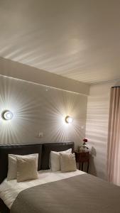 T&L Apartments Agiaos Tychonas في ليماسول: غرفة نوم بسرير مع وجود مصباحين على السقف