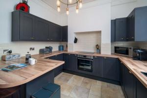uma cozinha com armários pretos e um balcão de madeira em Wheatsheaf House, Cowes em Cowes