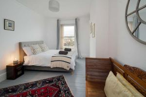um quarto branco com uma cama e uma janela em Wheatsheaf House, Cowes em Cowes
