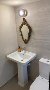 a bathroom with a sink and a mirror on the wall at T&L Apartments Agiaos Tychonas in Limassol