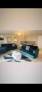 a living room with a blue couch and a table at Luxurious Beach Front Apartment in Portrush in Portrush