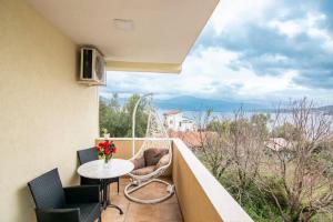 a balcony with a table and chairs and a view of the ocean at Apartments Savić in Herceg-Novi