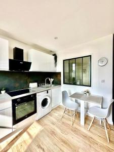 a kitchen with a table and a washing machine at Appartement Cosy centre-ville in Ribérac