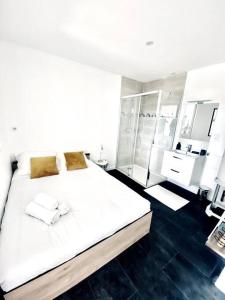 a bedroom with a large white bed and a mirror at Appartement Cosy centre-ville in Ribérac