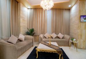 a living room with two couches and a chandelier at فندق سما سول للشقق in Mecca