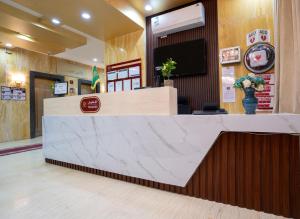 a lobby with a reception desk and a tv at Orvana Soul Serviced Apartments in Mecca