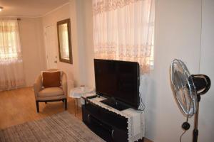 sala de estar con TV de pantalla plana y ventilador en Belle Zoon Villa en Cap Estate