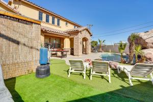 a yard with chairs and a pool and a house at North Las Vegas Home about 9 Mi to the Strip! in Las Vegas