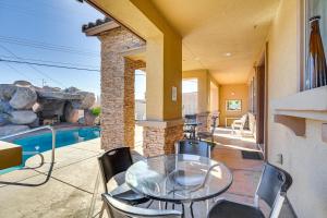 a glass table and chairs on a patio with a pool at North Las Vegas Home about 9 Mi to the Strip! in Las Vegas