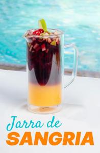 a glass jar of sangria next to a pool at HOTEL CLUB MORAZAN in San Lorenzo