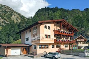 a large building with people on a balcony at Apart Alpina Huben in Längenfeld