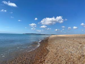 een strand met rotsen en de oceaan op een zonnige dag bij Little Mount, Rye in Rye