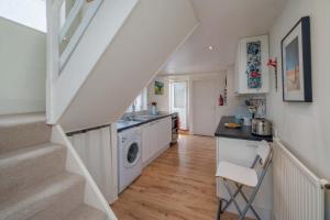 une cuisine avec un lave-linge et un escalier dans l'établissement Windward cottage, a great 3bed house in Cowes, à Cowes
