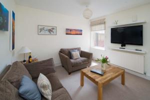 a living room with a couch and a tv at Windward cottage, a great 3bed house in Cowes in Cowes