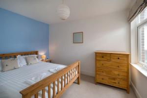 um quarto com uma cama de madeira e uma cómoda de madeira em Windward cottage, a great 3bed house in Cowes em Cowes