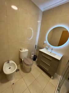 a bathroom with a toilet and a sink and a mirror at Sunflower Apartment in Armação de Pêra +17 photos