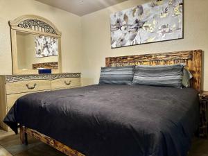 1 dormitorio con cama, tocador y espejo en The Rustic @ Paseo de Encinal Drive, en Eagle Pass