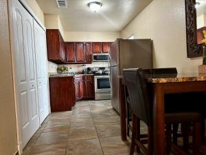a kitchen with wooden cabinets and a stainless steel refrigerator at The Rustic @ Paseo de Encinal Drive in Eagle Pass