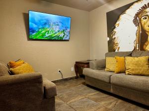 a living room with two couches and a flat screen tv at The Rustic @ Paseo de Encinal Drive in Eagle Pass
