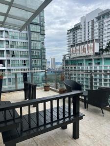 a balcony with a bench and some buildings at KLCC Cormar Premium Suites at Kuala Lumpur City Center in Kuala Lumpur