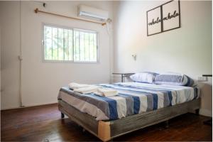 a bedroom with a bed with blue and white sheets at Eleven in Posadas