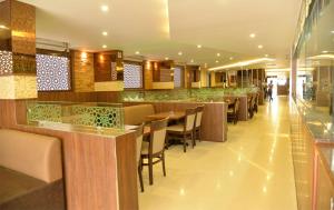 a restaurant with a bar with tables and chairs at Hotel ABM International in Bangalore