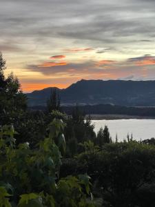 a sunset over a body of water with mountains at Mirador Valeisa in Guatavita