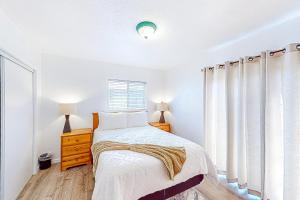 a white bedroom with a bed and a window at La Marsielle 256 in Pismo Beach