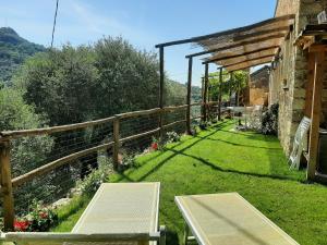 a garden with a table and benches in the grass at Guesthouse Contrada Bolla in Finale Ligure