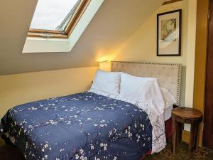 a bedroom with a bed with a blue blanket and a window at Bluebird Guesthouse in Portland