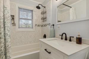 een witte badkamer met een wastafel en een spiegel bij Valley Vista-Mins to SkylineDrive-Hot Tub-King, Queen Beds in Front Royal