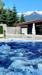 una piscina de agua con montañas en el fondo en 6 Luxury SPA Apartments TOP resort Bansko - incl wellness, en Bansko