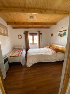 a bedroom with two beds and a window at Cabañas Voyage Atacama in San Pedro de Atacama