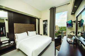 a hotel room with a large bed and a large window at Fair View Hotel Colombo in Colombo
