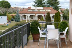 a balcony with a table and chairs and a house at 2 bedrooms chalet with private pool terrace and wifi at Villamayor in Villamayor