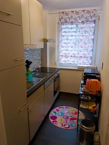 una pequeña cocina con fregadero y ventana en City Apartment, en Salzburgo