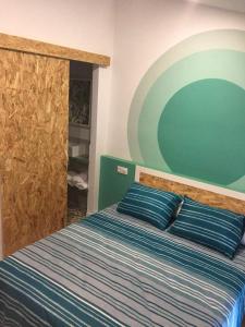 2 bedrooms appartement with terrace and wifi at Xativa في خاتيفا: غرفة نوم بسرير ومخدات زرقاء وجدار أخضر