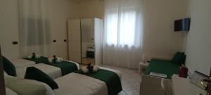 a hotel room with three beds and a mirror at G&G Giusy e Gabry in Santhià