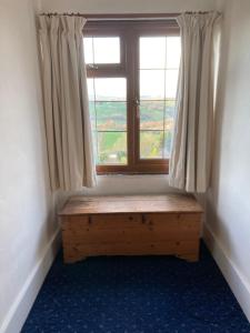 a window with a wooden bench in front of a window at Bryntirion Farmhouse Room with own bathroom in Llanfair Caereinion