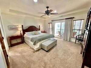 ein Schlafzimmer mit einem Bett und einem Deckenventilator in der Unterkunft Salty Shenanigans in Kill Devil Hills