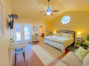 1 dormitorio con 1 cama y ventilador de techo en Comal Inn en New Braunfels