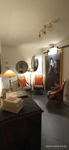Habitación con escritorio, sillas y una pintura en Jacona 365 en Palermo
